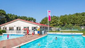 A swimming pool area with a building labeled 'NIEUEN DUIKEN' and a flag. - Cozy Chalet in the Dune Region (Egmond aan den Hoef)