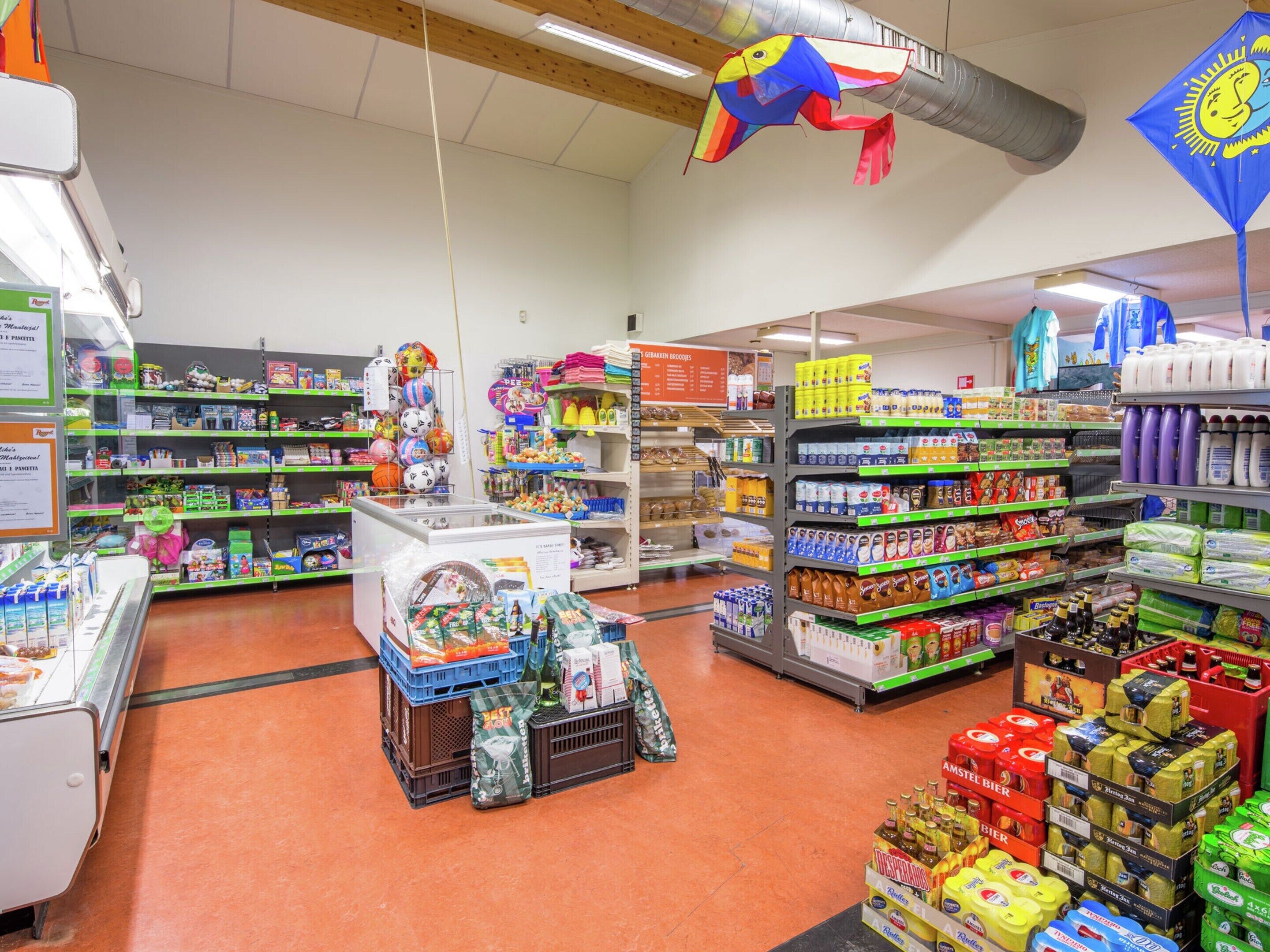 A grocery store with various aisles stocked with products, including dairy, snacks, and household items.