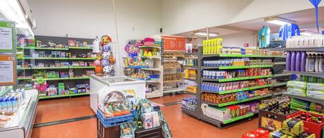 A grocery store with various aisles stocked with products, including dairy, snacks, and household items.