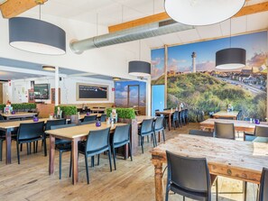 Enjoy a warm and inviting dining experience with a variety of seating options and a scenic mural.