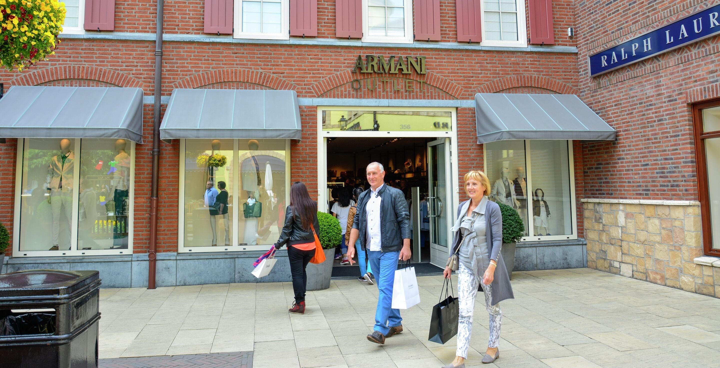 A brick building with a storefront named 'ARMANI OUTLET.'