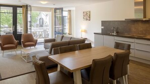 A modern kitchen with a built-in stove and a dining area with a wooden table and chairs.