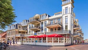 A multi-story building with balconies and outdoor seating.