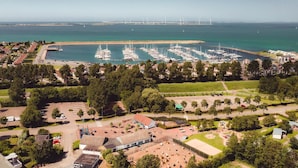 An aerial view of a marina with numerous boats docked, surrounded by residential buildings and greenery. - Bungalow in Netherlands With Private Sauna (Kamperland)