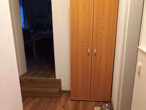 A wooden wardrobe with two doors and a small step leading to a dark room. - Enticing Apartment in Stormbruch near Ski Area (Diemelsee)