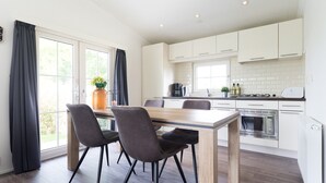 Una cucina moderna con mobili bianchi, un tavolo da pranzo in legno e quattro sedie.