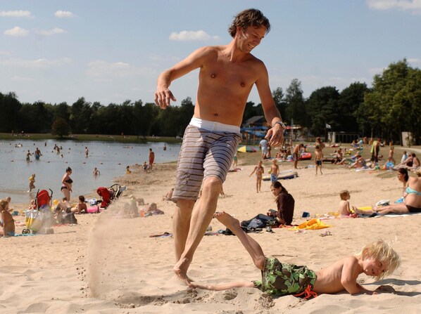 A beach scene with people sunbathing and swimming. - Bungalow in Bospark 't Wolfsven Near Nature (Mierlo)
