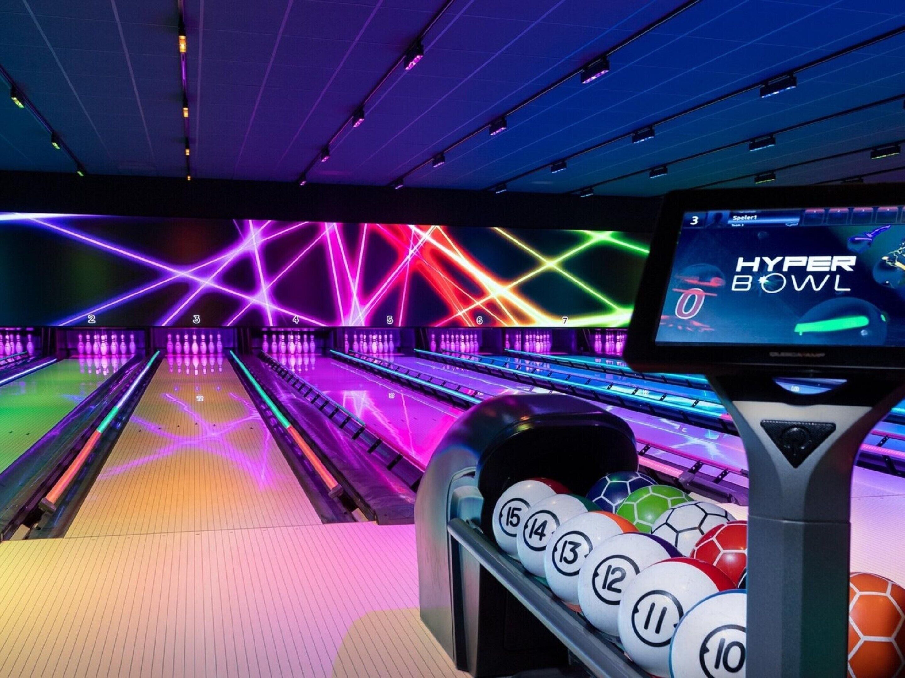 A bowling alley with neon lights and a screen displaying "Hyper Bowl".