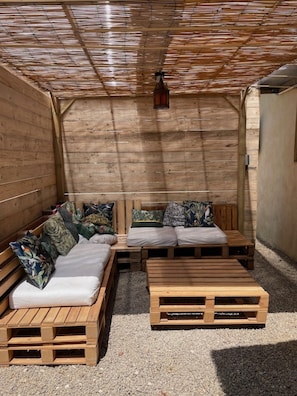 A wooden room with a sloped ceiling, a bench, a sofa, and a small table.