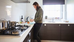 Une cuisine moderne équipée d’une cuisinière à gaz, d’une machine à café et d’une fenêtre donnant sur un beau paysage.