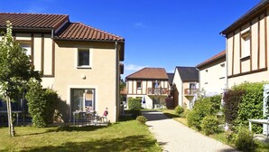 A residential building with a tiled roof, a front door, and a small garden area with a pathway leading to the entrance. - Holiday Home in Montignac Near Lascaux II (Montignac)