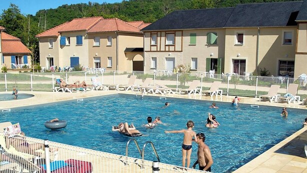 A swimming pool with lounge chairs and a building with a tiled roof in the background. - Holiday Home in Montignac Near Lascaux II (Montignac)