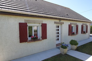 A single-story building with a sloped roof, a front door, and windows with shutters. - Sea View Family Escape (Port-Bail-sur-Mer)