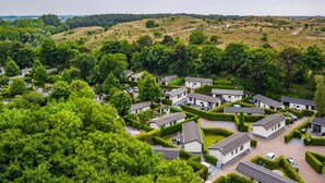 A residential area with houses arranged in a grid pattern, surrounded by lush greenery and hills in the background. - Cozy Chalet With Dishwasher in Noordwijk, Near the Sea (Noordwijk)
