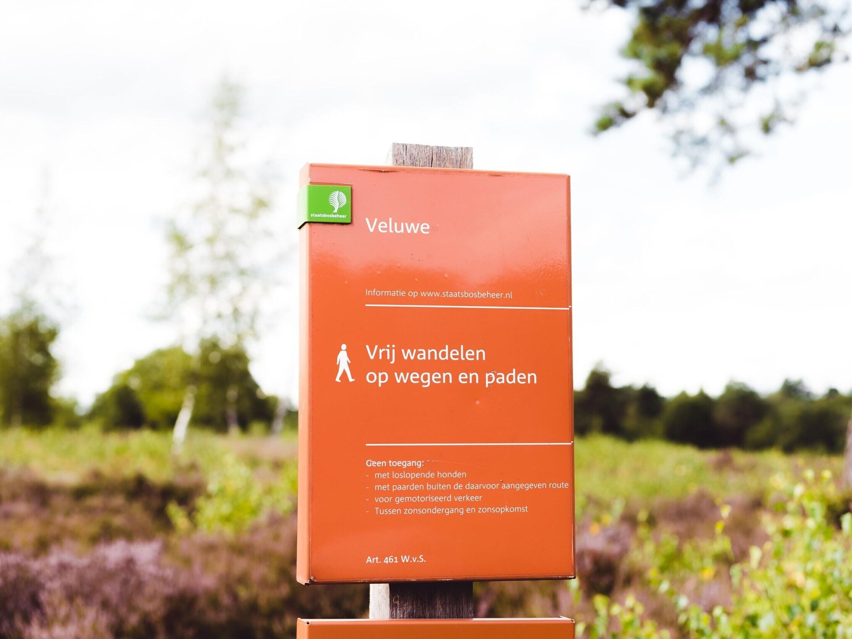 A sign with the text "Vij wandelen op wegen en paden" and "Geen toegang" indicating no access for walking on roads and paths.