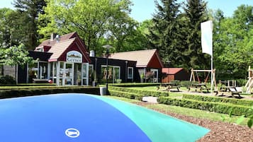 Guests can enjoy a well-maintained outdoor area with a play structure and a nearby business establishment.