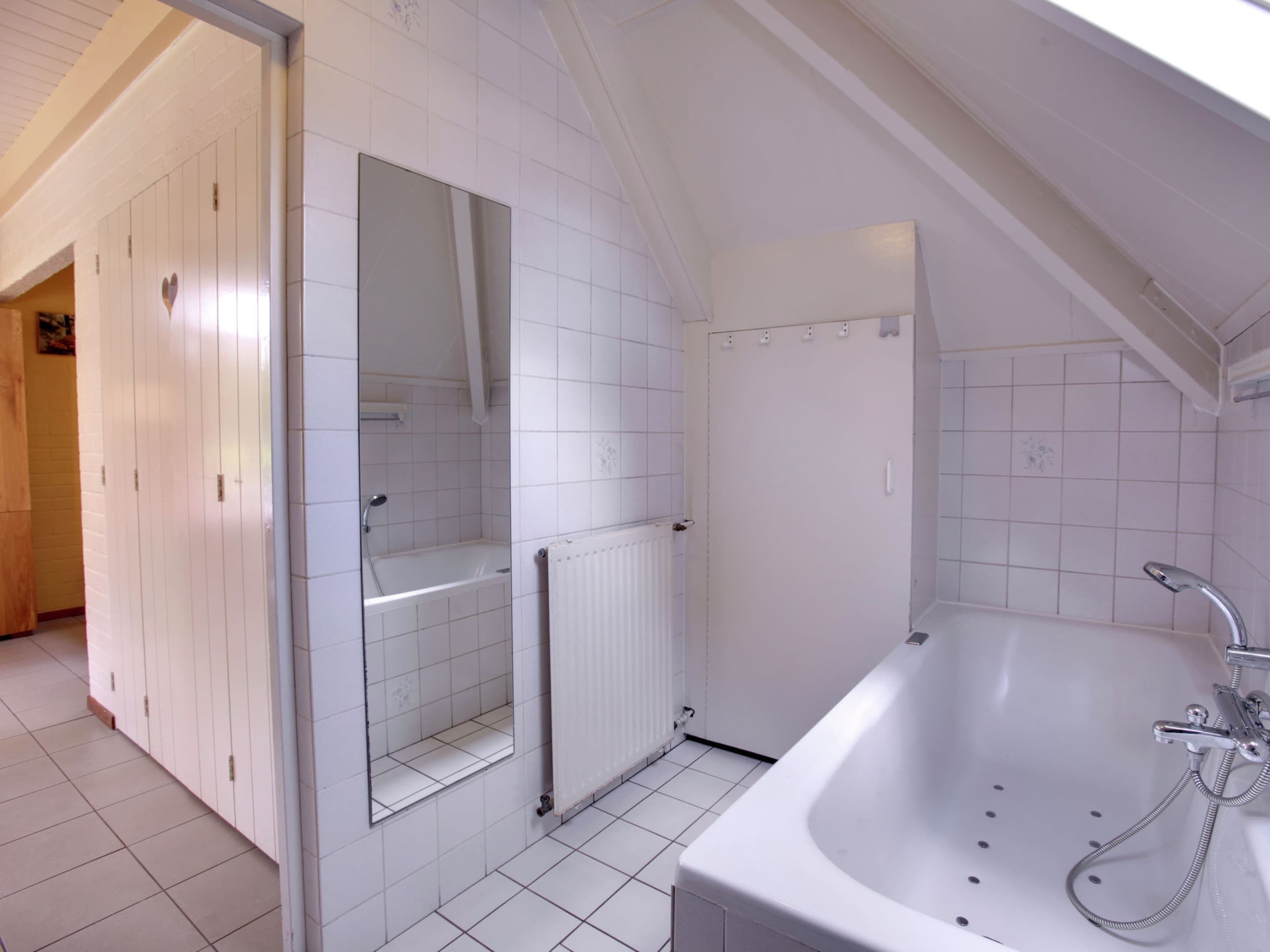 A modern bathroom with a bathtub, a shower, and a toilet.