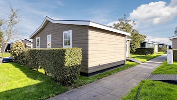 A single-story mobile home with a flat roof, a front door, and a small porch area.