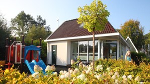 A building with a tiled roof, a glass door, and a sign that reads "RECEPTION". - Detached Holiday Home in Schoorl With Garden (Schoorl)