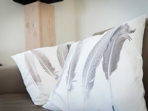 A pillow with a feather design on a couch. - Well-furnished Home With a Porch Near the Sea (Noordwijk)
