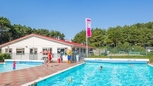 Zona de piscina con un edificio que dice 'NIEUEN DUIKEN' y una bandera.