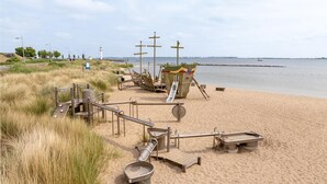 Uma praia com um naufrágio e diversos objetos de metal.