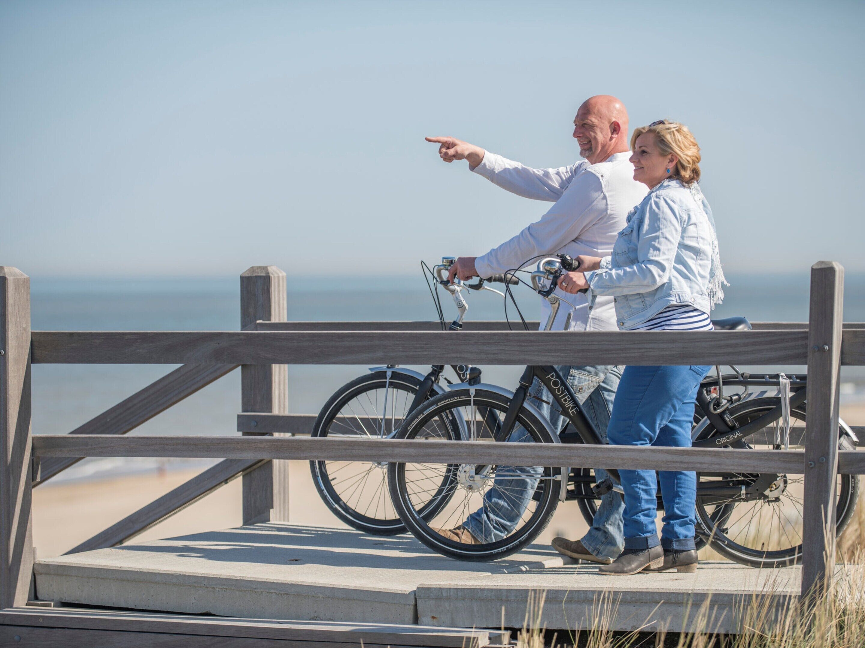 Une jetée en bois où sont garés des vélos, surplombant une étendue d’eau.