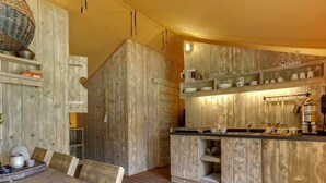 A rustic kitchen with wooden cabinets and a wooden dining table. - Apartment in Netherlands Near Scenic Canals (Uden)