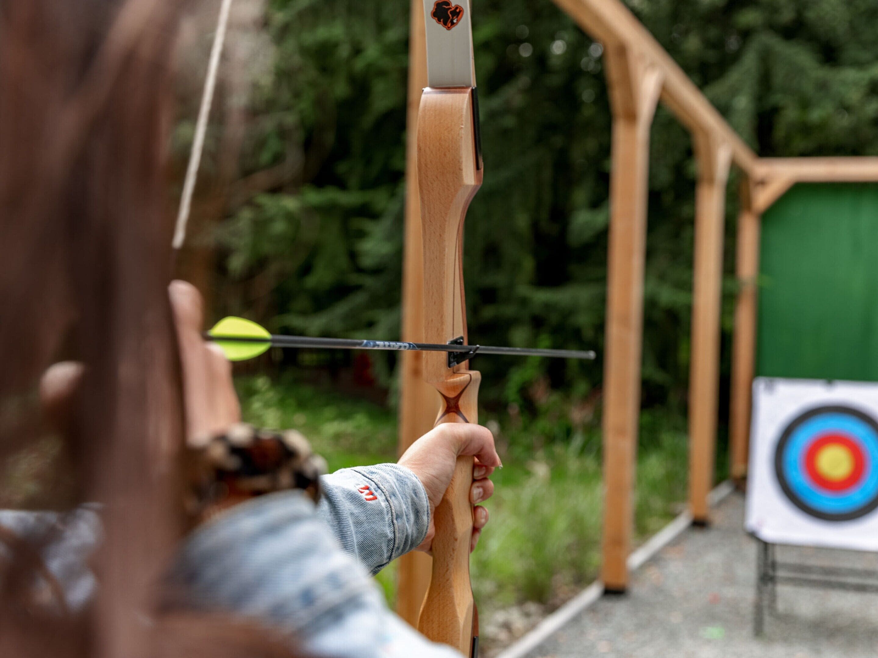 A person aiming a bow at a target.
