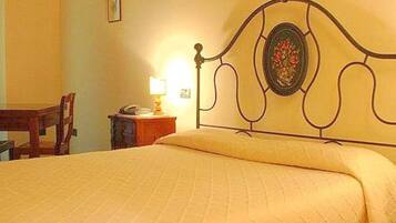 Une chambre avec un lit, une table de chevet, une chaise et une lampe.