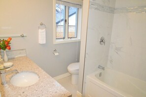 A bathroom with a sink, toilet, and shower.