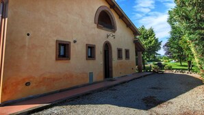 A building with a beige facade, a central arched entrance, and small windows. - Tuscan Retreat With Pool (Cortona)