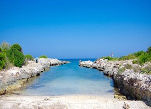 A coastal scene with rocky shores and clear blue water.