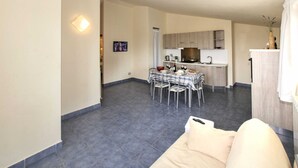 A compact living space with a dining area, kitchenette, and a sofa.
