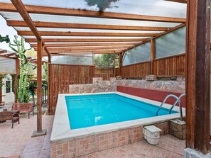 Relax by the pool surrounded by a shaded pergola and comfortable seating areas.
