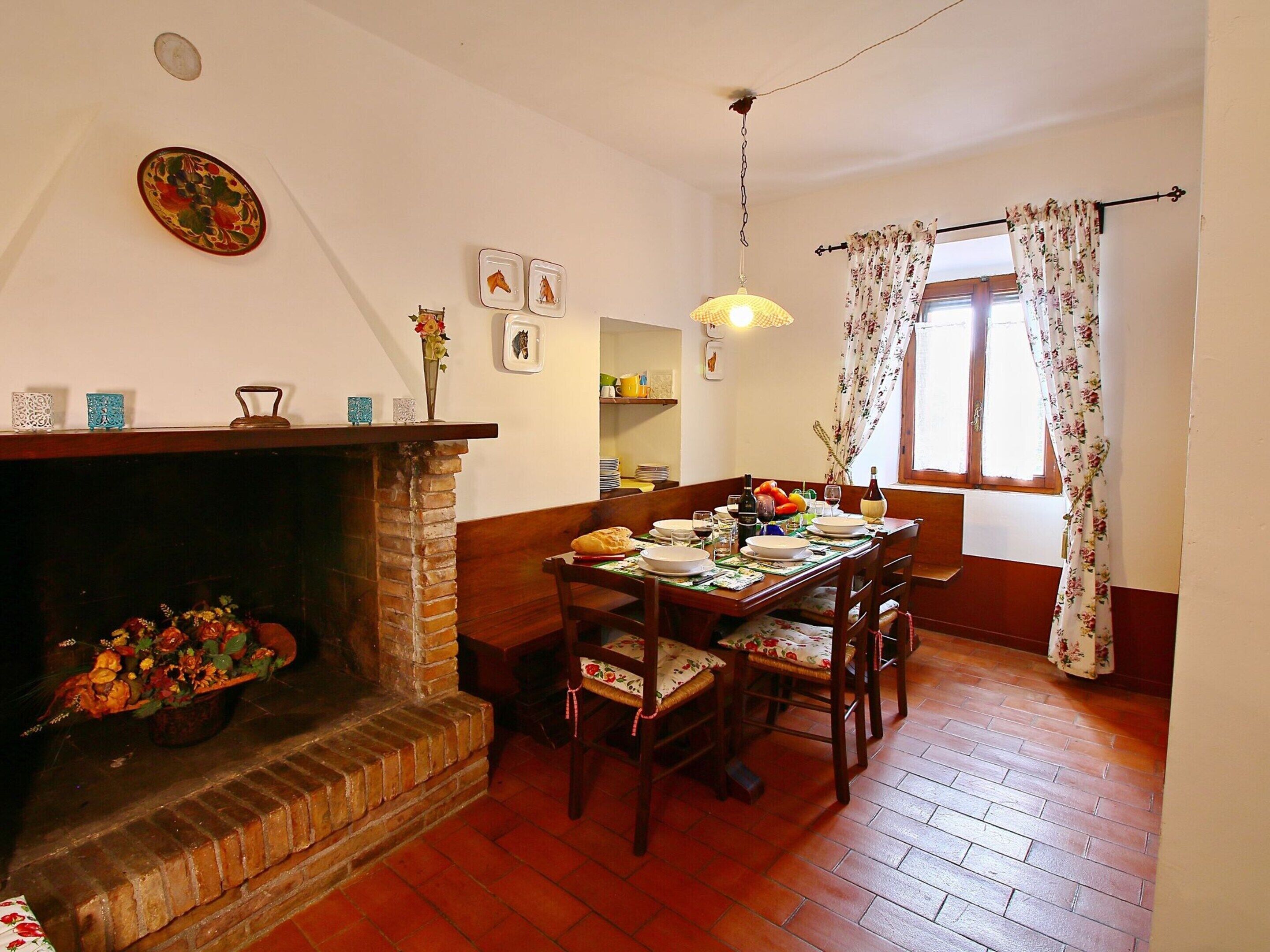 Comedor con chimenea de ladrillo, mesa de madera y sillas.