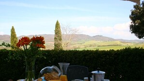 A breakfast table with a view of rolling hills and a clear sky. - Spacious House in Pienza (Pienza)