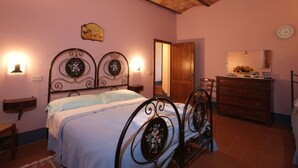 A bedroom with a bed, dresser, and a mirror. - Spacious House in Pienza (Pienza)