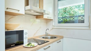 A modern kitchen with a built-in microwave, stainless steel sink, and wooden countertop.