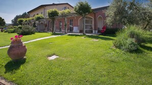 A villa with a well-maintained garden, outdoor seating, and a large patio area. - Tuscan Stay w/ Jacuzzi (Grosseto)