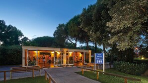 A gym area with exercise equipment, a wooden bench, and a sign indicating operating hours. - Chalet in Baia Domizia With Private Beach (Cellole)