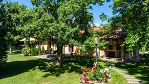 A courtyard with a gazebo, a stone pathway, and a building with a red-tiled roof. - Charm Farmhouse With Pool (Castiglion Fiorentino)