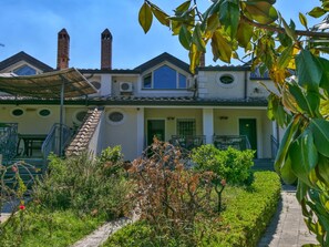 A two-story house with a garden, a staircase, and a chimney.
