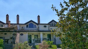 A two-story building with a garden pathway leading to a green door. - Holiday Home in San Cipriano With Pool (San Cipriano Picentino)