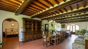 A spacious dining area with a large wooden table, chairs, and a built-in cabinet.