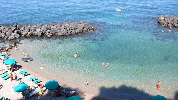 A beach with clear water, rocky breakwaters, and sun loungers. - Cozy Holiday Home in Trecase With Balcony - Casa per Ferie (Trecase)