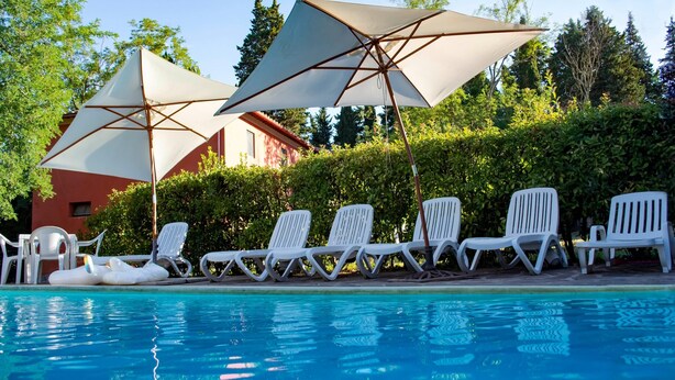 A pool area with lounge chairs and umbrellas. - Spacious Tuscan Farmhouse (Peccioli)
