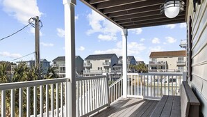 A wooden deck with white railings, overlooking a residential area with houses and a water tower. - Close To Ocean Pet Friendly 6 Bedroom / 5 Bath Private Home with Private Pool (North Myrtle Beach)