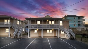 Un motel composé d’un bâtiment central et de deux ailes latérales, doté d’un parking couvert et offrant une vue magnifique sur le coucher de soleil.