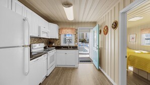 A compact kitchen with white cabinets, a microwave, and a stove. - Short walk to Beach, 2 Bedroom/1 Bath Quad 2 (down) pool access near Main St (North Myrtle Beach)